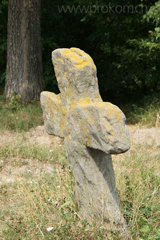 ein golden leuchtendes Kreuz steht da am Wegrand