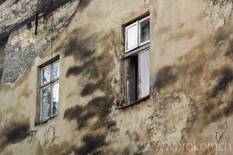 Eine ganz normale Hauswand mit Fenstern in Lwiw